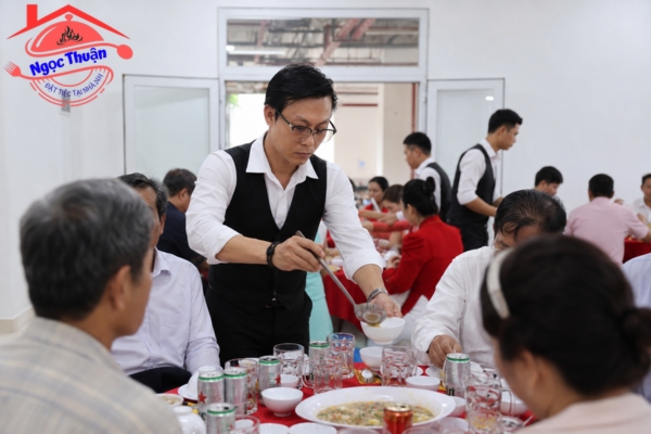Nhân viên phục vụ chia món ăn trên bàn cho khách mời